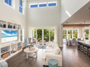 a living room with white furniture and a tv at Luxe Island Escape in Anna Maria
