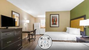 a hotel room with a bed and a desk with a television at Extended Stay America Suites - Columbia - West - Interstate 126 in Columbia