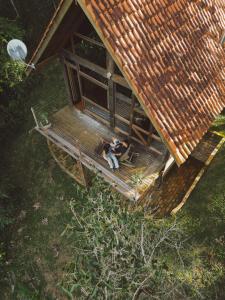 an overhead view of a couple sitting on the porch of a tiny house at Reserva Santo Antônio in Santo Antônio do Pinhal