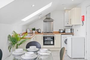 a kitchen with a glass table and a stove at NEW 5 Sarah House by Truestays - 2 Bedroom Apartment - FREE Parking in Manchester
