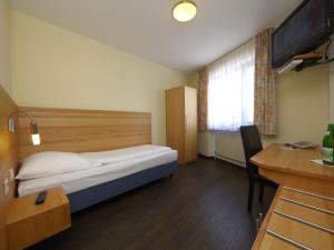 a bedroom with a bed and a window and a desk at Hotel Pinger in Remagen +53 photos