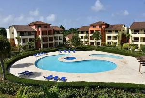 a pool at a resort with chairs and condos at MagicCana arena blanca beach in Punta Cana