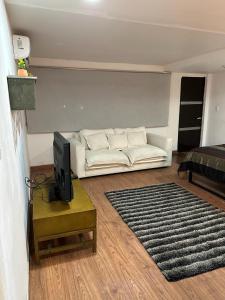 a living room with a white couch and a tv at Mi Delicioso Escape in San Luis Río Colorado +13 photos