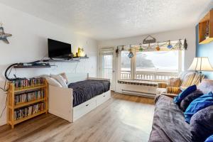 1 dormitorio con 1 cama, TV y sofá en Neskowin Resort Unit #203, en Neskowin