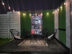 Max´s House في Ahuachapán: طاولة وكراسي أمام جدار أخضر