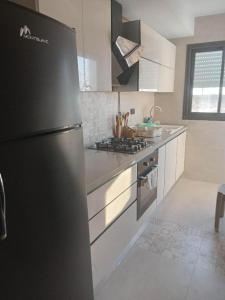 a kitchen with a black refrigerator and a stove at Vip Tunisia center in Tunis