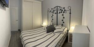 1 dormitorio con 1 cama con sábanas de rayas en blanco y negro en Apartment zona Naturista, en Vera
