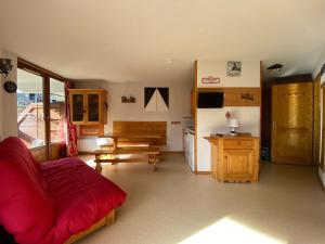a living room with a red couch and a kitchen at Appartement Morillon 1100, 2 pièces, 6 personnes - FR-1-642-62 in Morillon