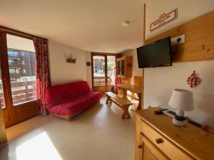 a living room with a red couch and a flat screen tv at Appartement Morillon 1100, 2 pièces, 6 personnes - FR-1-642-62 in Morillon