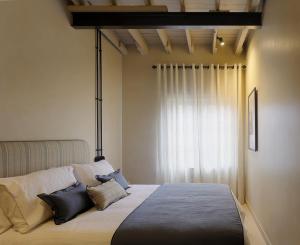 um quarto com uma cama com almofadas e uma janela em APARTAMENTO DISEÑo GALIANA 6 ARENA AVILÉS ASTURIAS em Avilés