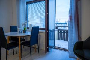 a dining room with a table and chairs and a balcony at Cozy Apartment by the Sea in Kemi