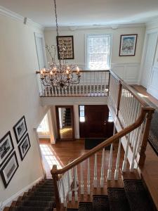 a staircase with a chandelier in a house at 5 Plus Bedroom Over Sized Colonial in Very Private Setting in Pound Ridge
