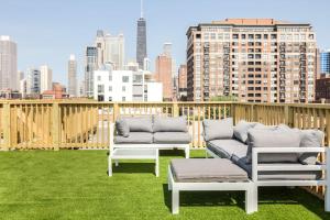 two couches and a table on a balcony with a city skyline at The Orleans - Floor 2 Private roof deck Patio in Chicago