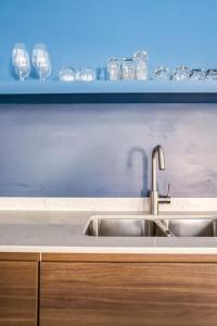 a kitchen with a sink and wine glasses on a shelf at The Orleans - Floor 2 Private roof deck Patio in Chicago