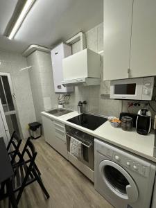 a kitchen with a sink and a washing machine at A 5 min del aeropuerto + IFEMA in Madrid