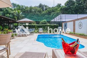 una piscina con amaca rossa accanto al resort di Casa com piscina natural e lazer em Guapimirim a Guapimirim