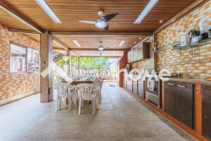 una cucina con tavolo, sedie e ventilatore a soffitto di Casa com piscina natural e lazer em Guapimirim a Guapimirim