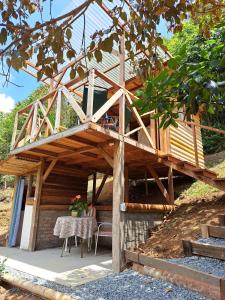 une maison en bois avec une table et des chaises devant elle dans l'établissement Entre Arboles Cali, à Cali