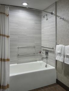a bathroom with a tub and a shower with towels at Atlanta Marriott Peachtree Corners in Norcross