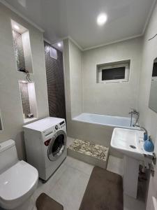 a bathroom with a washing machine and a sink at Люкс 2-х комнатная квартира in Taraz
