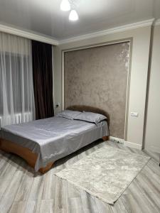 ein Schlafzimmer mit einem Bett und einem Teppich in der Unterkunft Люкс 2-х комнатная квартира in Taras