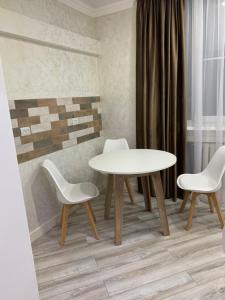 einen weißen Tisch und zwei Stühle sowie einen Tisch und Stühle in der Unterkunft Люкс 2-х комнатная квартира in Taras