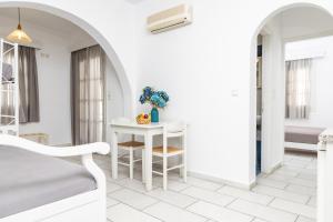 Habitación blanca con mesa y cama en Depis studios & apartments, en Naxos Chora
