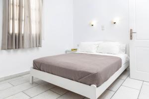 a white bedroom with a bed and white walls at Depis studios & apartments in Naxos Chora