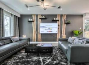 ein Wohnzimmer mit 2 Sofas und einem Bildschirm in der Unterkunft Vihome001C1-4-Bedrooms(Fairview Mall and 401+DVP) in Toronto