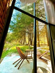 una ventana con 2 sillas y una mesa al aire libre en Cabaña Hermosa Bosque Privado 19 en Mineral del Monte