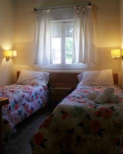 1 dormitorio con 2 camas y ventana en Hostería Robert en Villa Gesell