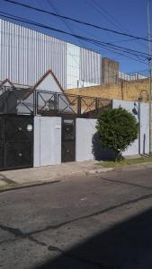 a white building with black doors on the side of a street at Casa en Munro con habitación individual in Munro