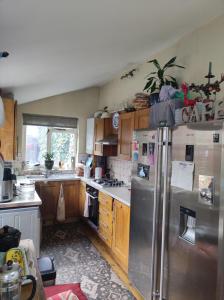 a kitchen with wooden cabinets and stainless steel appliances at Cosy London single room (near Wimbledon) in London