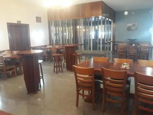 a dining room with wooden tables and chairs at Hotel Fazenda Valaisan in Santa Maria Madalena