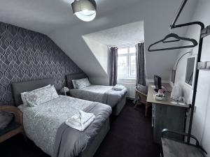 una camera d'albergo con due letti e una televisione di DunMoore Guesthouse a Oban