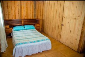a bedroom with a bed with blue pillows on it at Pozas Guacimo in Guápiles