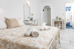 1 dormitorio con 1 cama con toallas en Depis studios & apartments, en Naxos Chora