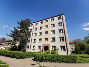 a large white building with bushes in front of it at Apartament Parkowe Love in Chorzów