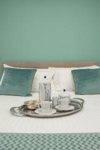un vassoio con set per la preparazione del tè e candele su un letto di Maison Morghen a Napoli