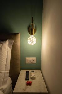 a room with a bed with a lamp and remote controls at Maison Morghen in Naples