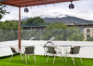 een patio met stoelen en een tafel en uitzicht op een berg bij El puente Hotel Boutique in Arequipa