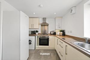 a kitchen with white cabinets and a sink at NEW 4 Sarah House by Truestays - 2 Bedroom Apartment - FREE Wifi & Parking in Manchester