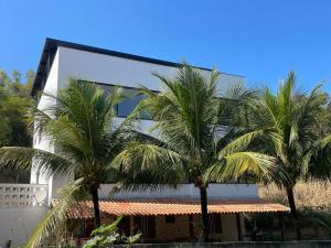 two palm trees in front of a building at Reserva Santa Helena in Anchieta