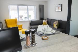 a living room with a table with a wine glass at Hope Apartments Belfast - Tullymore in Belfast