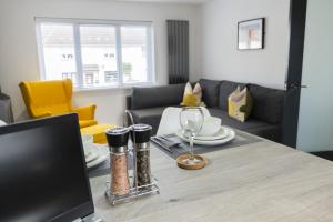 a living room with a table with a wine glass at Hope Apartments Belfast - Tullymore in Belfast +26 photos