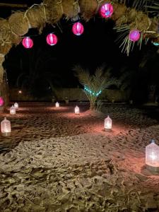 - un groupe de lanternes sur une plage la nuit dans l'établissement غزاله كامب, à Siwa