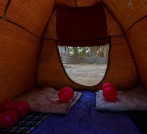 ein kleines Bett in einem Zelt mit Fenster in der Unterkunft غزاله كامب in Siwa