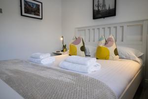 a white bed with towels and pillows on it at Hope Apartments Belfast - Tullymore in Belfast