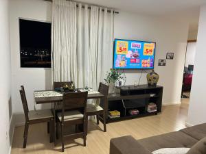 a living room with a dining room table and a television at Apartamento in Paranoá