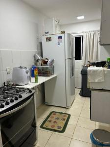 a kitchen with a white refrigerator and a stove at Apartamento in Paranoá